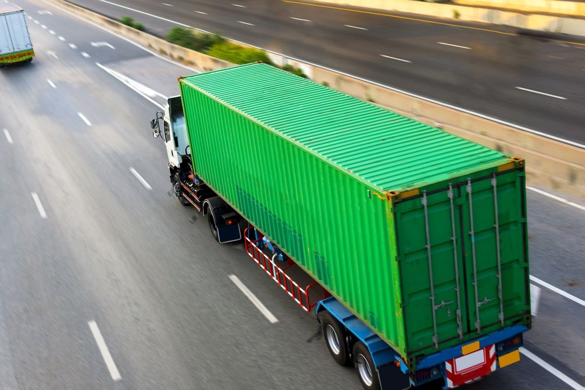 Truck on highway road with green container, transportation concept,import,export logistic industrial Transporting Land transport on the asphalt expressway.motion blurred to soft focus